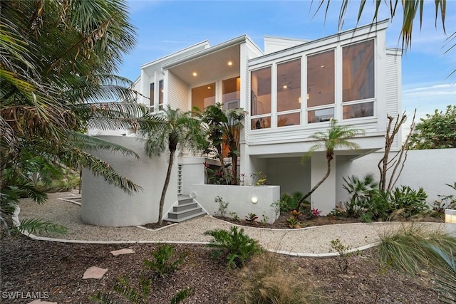 view of property exterior with a sunroom