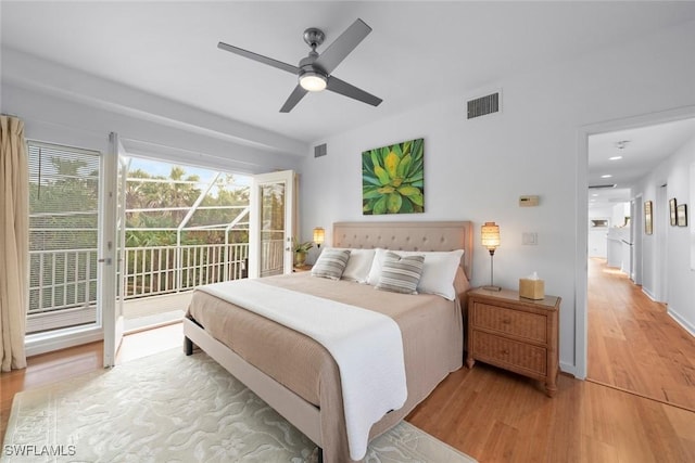 bedroom with multiple windows, hardwood / wood-style floors, access to outside, and ceiling fan