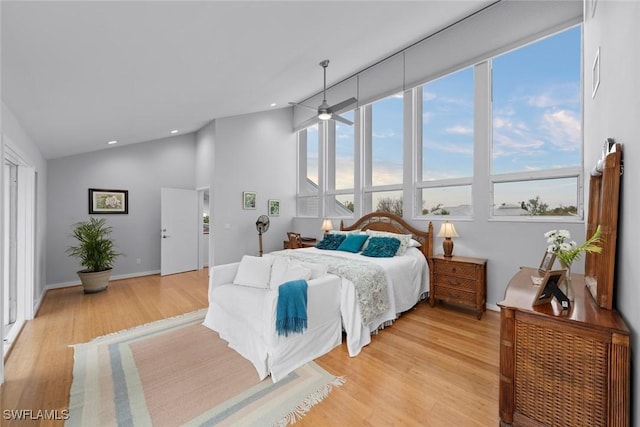 bedroom with lofted ceiling and light hardwood / wood-style floors