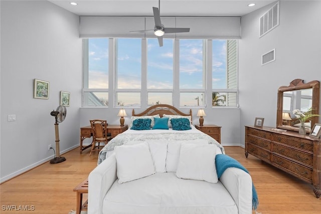 bedroom featuring multiple windows, light hardwood / wood-style floors, and ceiling fan