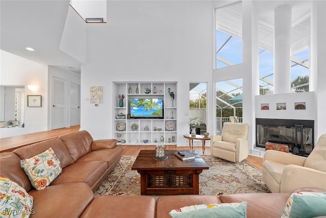 living room featuring a towering ceiling and wood-type flooring