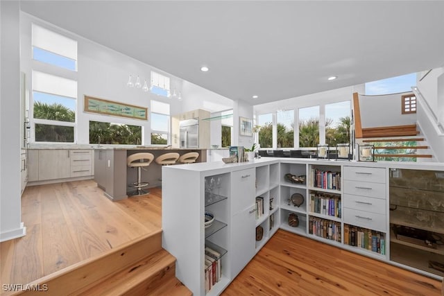 kitchen featuring white cabinetry, a wealth of natural light, kitchen peninsula, and stainless steel built in fridge