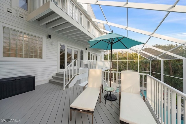 wooden terrace with a pool and glass enclosure