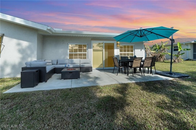 patio terrace at dusk featuring an outdoor hangout area and a yard