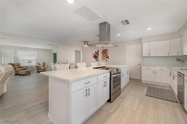 kitchen featuring white cabinetry, island range hood, stainless steel electric range oven, and a kitchen island