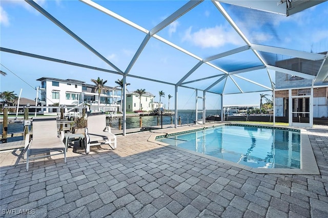 view of pool featuring a water view, a lanai, and a patio area