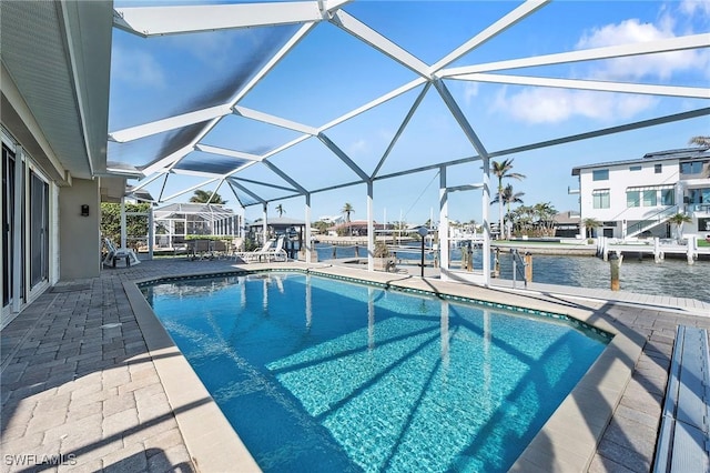 view of swimming pool featuring a patio, a water view, a boat dock, and glass enclosure