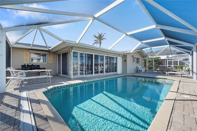 view of swimming pool featuring a lanai and a patio