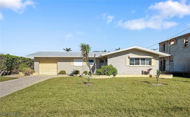 single story home featuring a garage and a front lawn