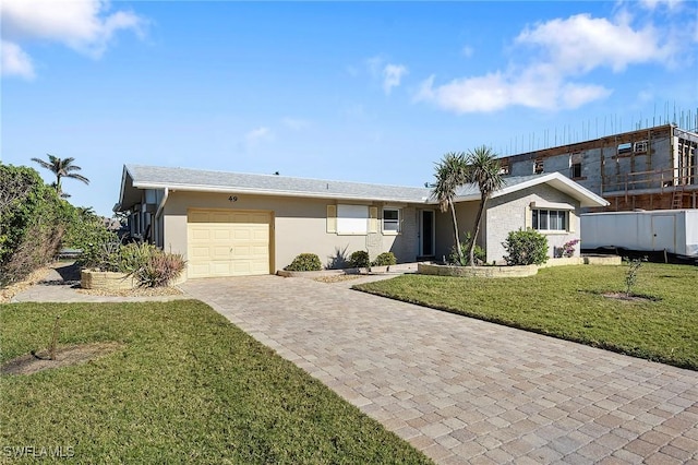 ranch-style house featuring a garage and a front lawn