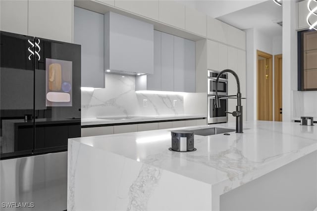 kitchen with white cabinets, double oven, decorative backsplash, electric cooktop, and light stone counters