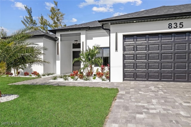 view of front of property featuring a garage and a front lawn