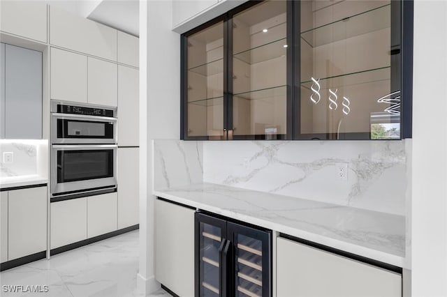 kitchen featuring white cabinetry, wine cooler, light stone counters, and stainless steel double oven