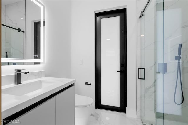 bathroom with toilet, a shower with shower door, and vanity