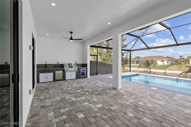 view of swimming pool with grilling area, ceiling fan, and sink