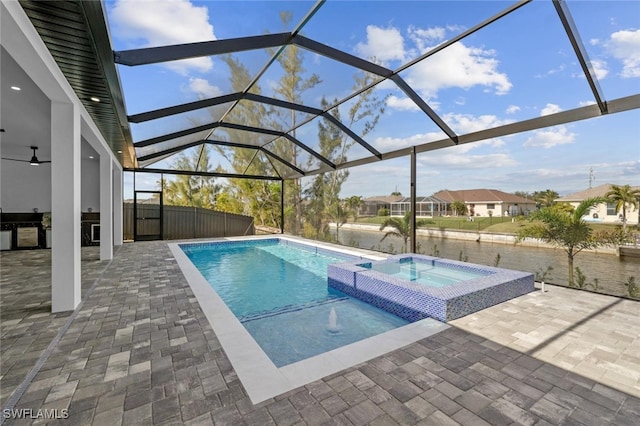 view of swimming pool with glass enclosure, an in ground hot tub, a water view, and a patio