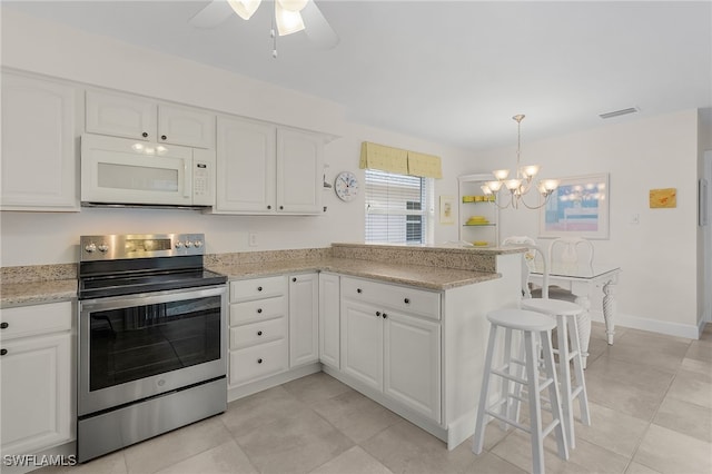 kitchen with white cabinets, decorative light fixtures, a kitchen breakfast bar, stainless steel electric range oven, and light stone counters