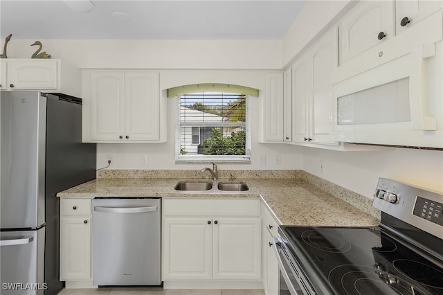 kitchen featuring light stone counters, sink, white cabinetry, and appliances with stainless steel finishes