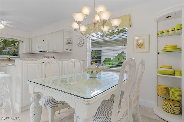 dining room with ceiling fan with notable chandelier, sink, and light tile patterned floors