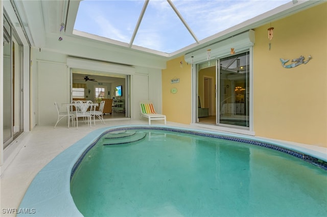 view of pool featuring glass enclosure and a patio