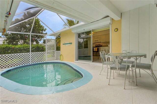 view of swimming pool with glass enclosure and a patio