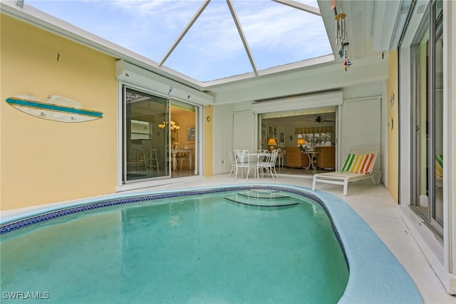 view of pool featuring glass enclosure and a patio area