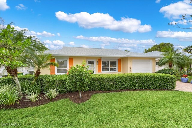 view of front of house with a garage and a front lawn