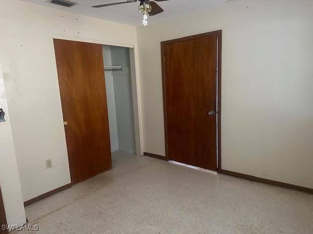 unfurnished bedroom featuring ceiling fan and a closet