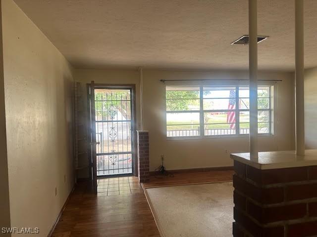 entryway featuring wood-type flooring and a textured ceiling