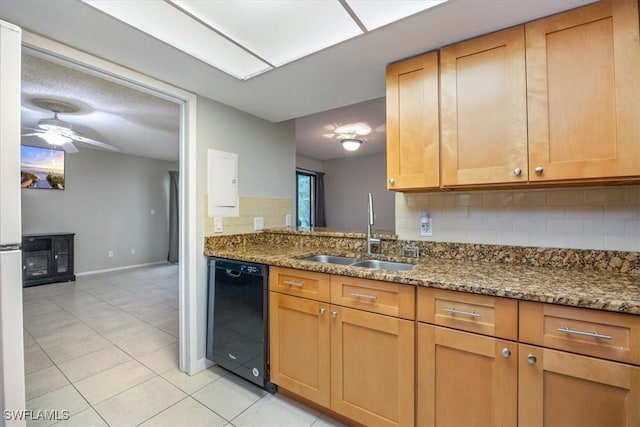 kitchen featuring tasteful backsplash, a ceiling fan, a sink, dark stone countertops, and dishwasher