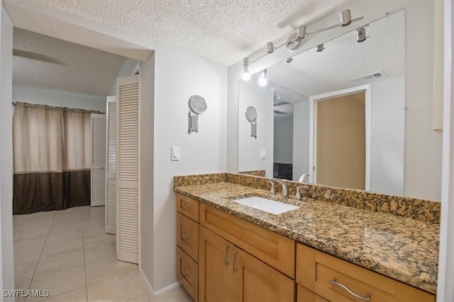 bathroom featuring a closet, visible vents, a textured ceiling, and vanity