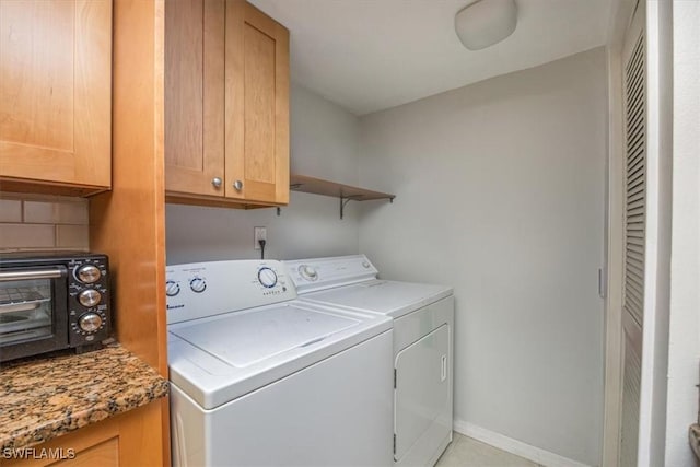 laundry room featuring baseboards, washer and clothes dryer, cabinet space, and a toaster