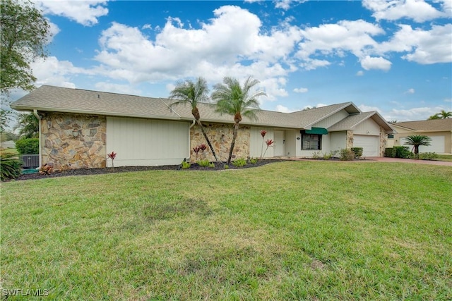 single story home featuring cooling unit, a garage, and a front yard