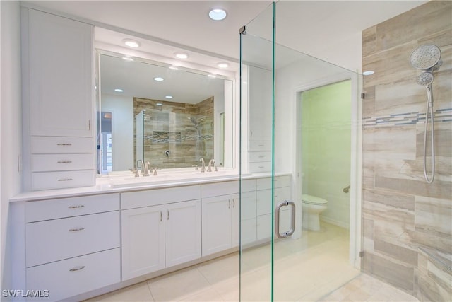 bathroom featuring vanity, an enclosed shower, tile patterned floors, and toilet