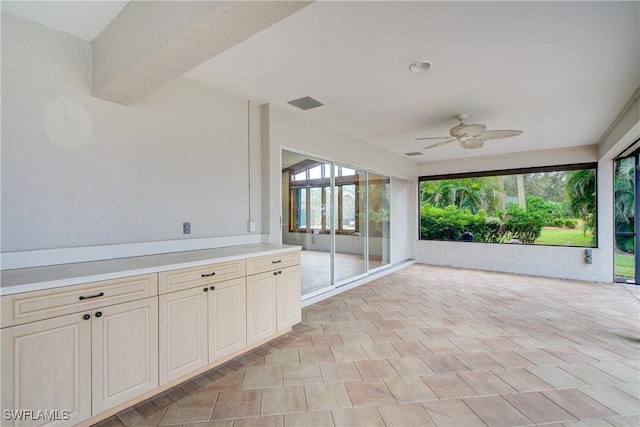 unfurnished sunroom with ceiling fan