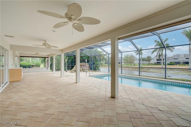 view of swimming pool with a water view, ceiling fan, a lanai, and a patio