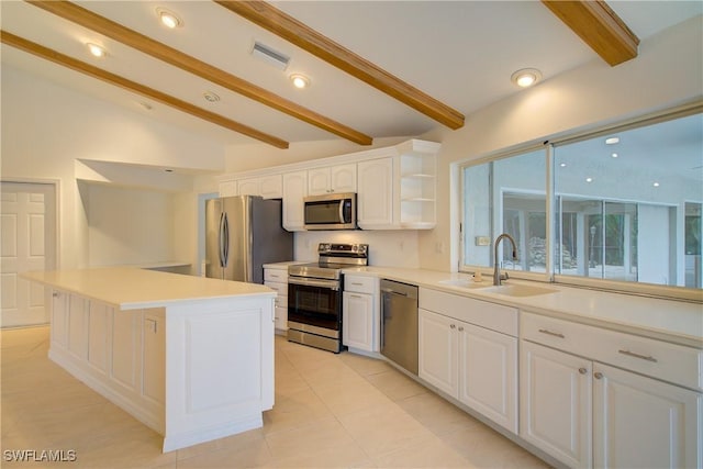 kitchen with a kitchen island, lofted ceiling with beams, sink, white cabinets, and stainless steel appliances