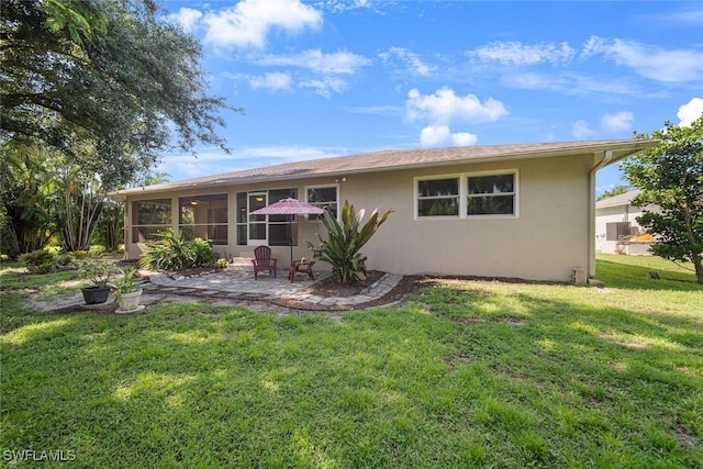 back of house with a sunroom, a lawn, and a patio