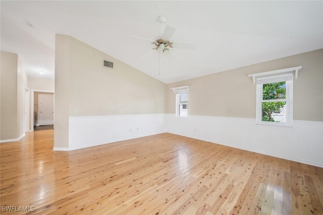 empty room with vaulted ceiling, ceiling fan, and light wood-type flooring