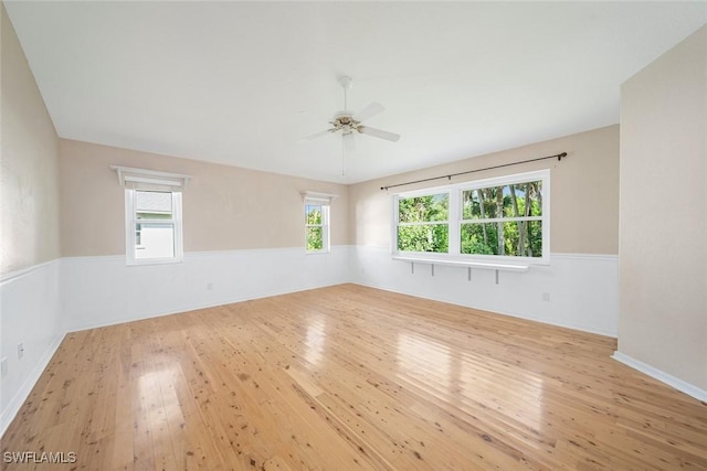 empty room featuring ceiling fan, light wood-type flooring, and plenty of natural light