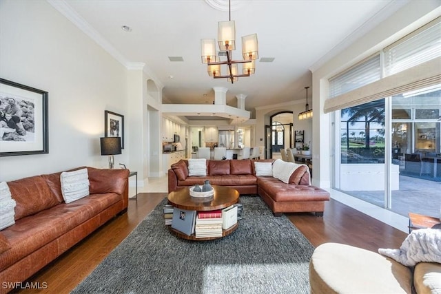 living room with a chandelier, crown molding, and dark wood-type flooring