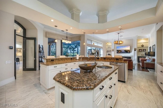 kitchen featuring a towering ceiling, hanging light fixtures, dishwasher, and a spacious island