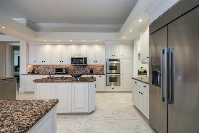 kitchen with white cabinetry, dark stone counters, and stainless steel appliances