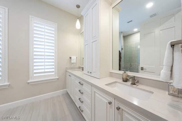 bathroom featuring walk in shower and vanity