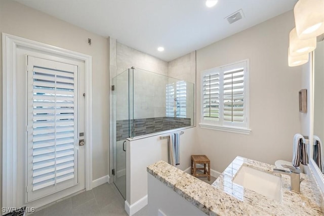 bathroom featuring a shower with door, tile patterned flooring, and vanity