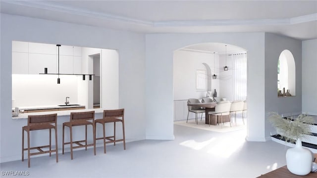 kitchen featuring white cabinets, concrete floors, and a kitchen breakfast bar