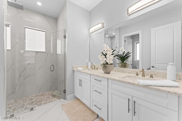 bathroom with a shower with door and vanity