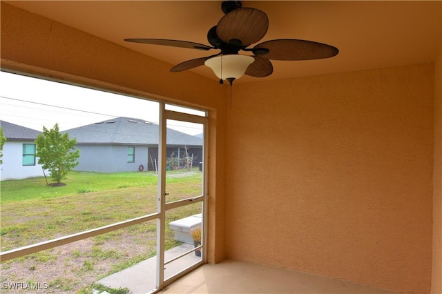 unfurnished sunroom with ceiling fan