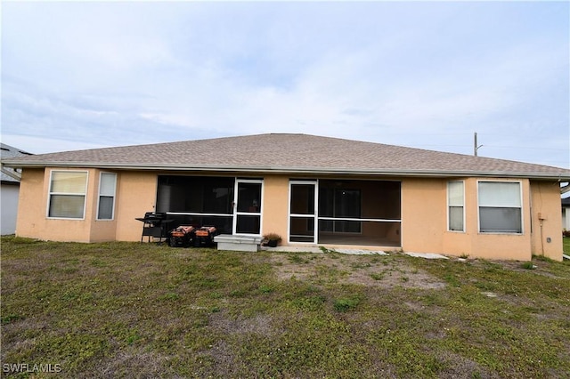 back of property with a yard and a sunroom