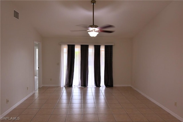 tiled empty room featuring vaulted ceiling and ceiling fan